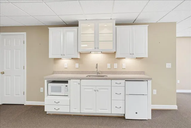a kitchen with white cabinets and sink