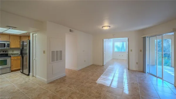 a view of a hallway with wooden floor and a living room