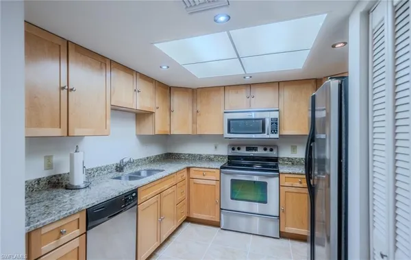 a kitchen with stainless steel appliances granite countertop a stove a sink and a refrigerator