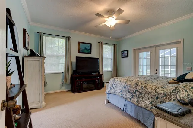 a bedroom with a bed flat screen tv and a window