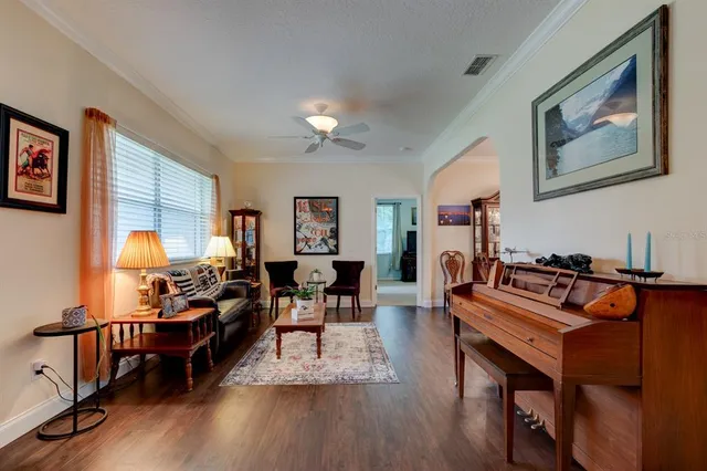 a living room with furniture a dining table and a piano next to a window