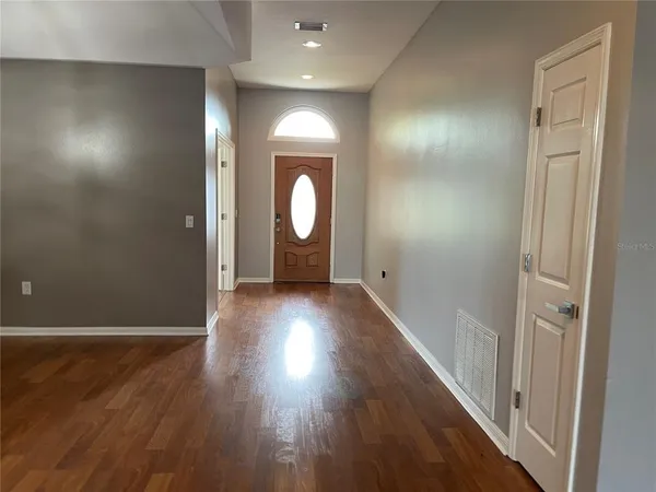 a view of a hallway with a chandelier fan