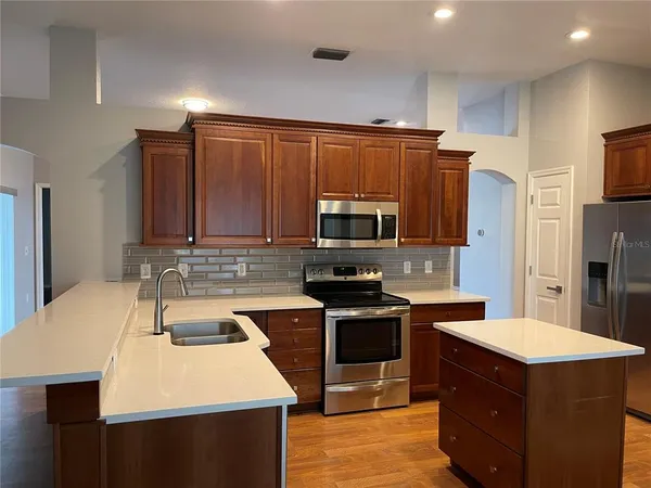 a kitchen with stainless steel appliances a sink and a refrigerator