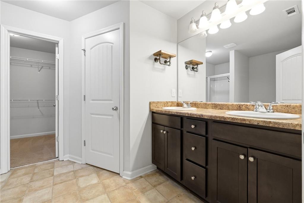 331 Turtle Creek Drive Winder, GA 30680 - Photo 16 of 25 a bathroom with a granite countertop sink a large mirror and a shower