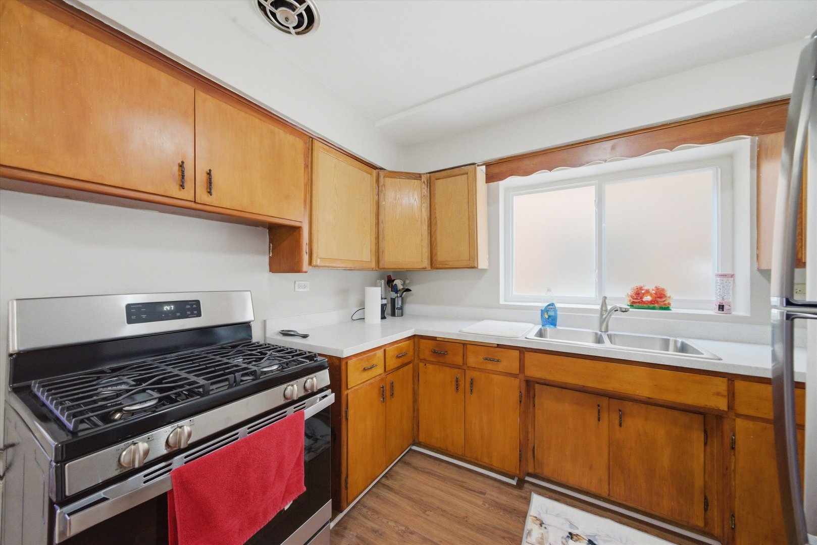 7412 West 63rd Place Summit, IL 60501 - Photo 20 of 49 a kitchen with a sink stove top oven and cabinets