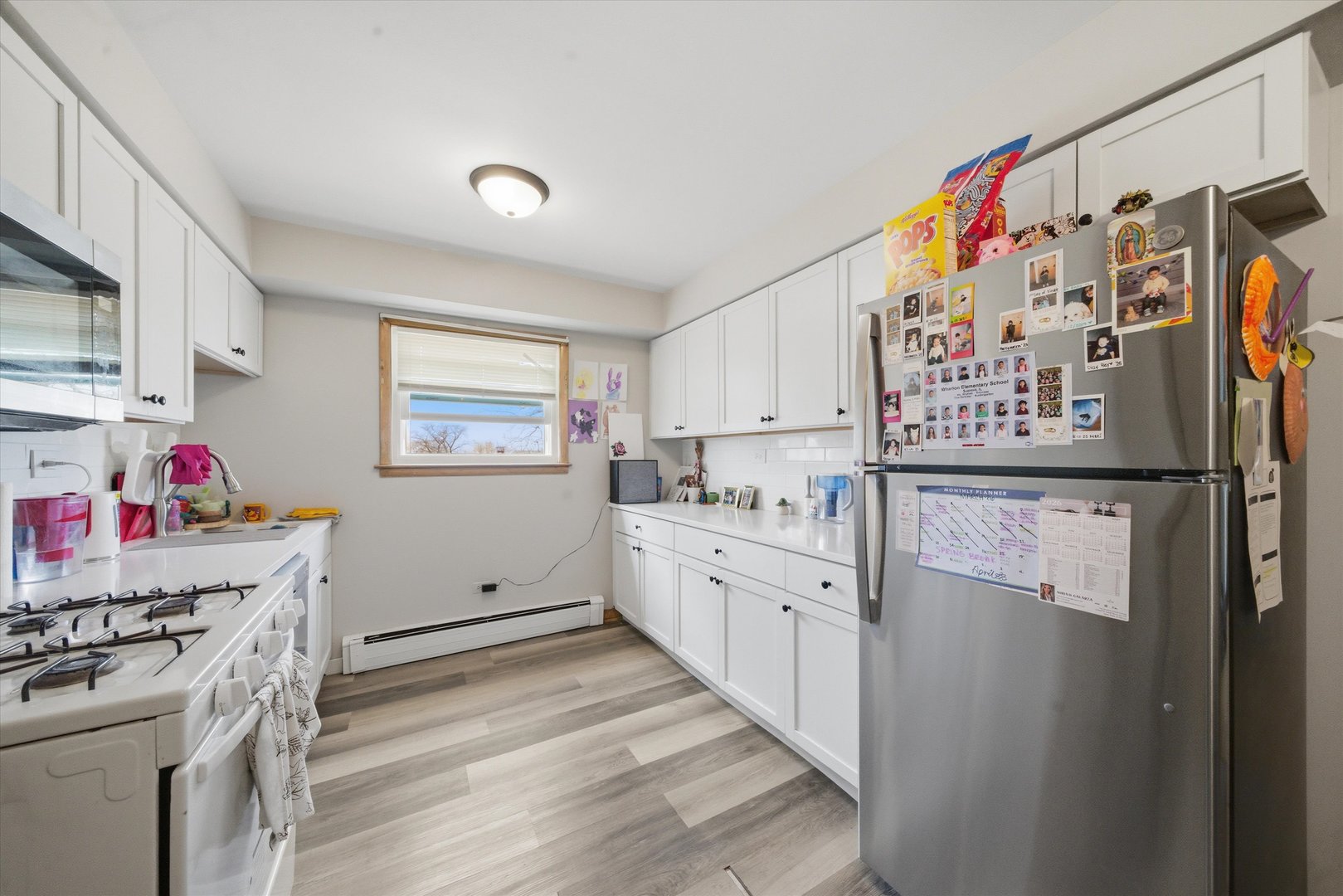 7412 West 63rd Place Summit, IL 60501 - Photo 41 of 49 a kitchen with white cabinets and white appliances