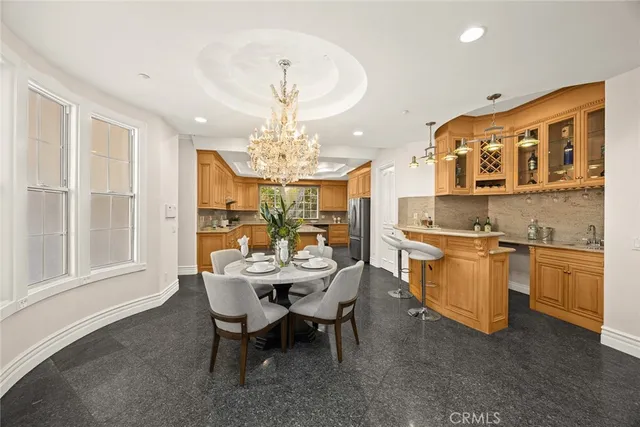 a view of a dining room with furniture a chandelier and kitchen view
