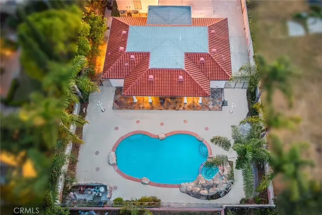 an aerial view of a house with swimming pool and outdoor space