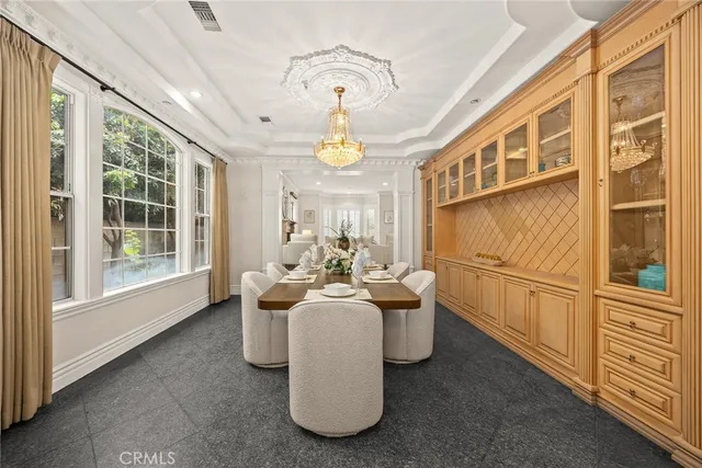 a living room with furniture a chandelier and a dining table