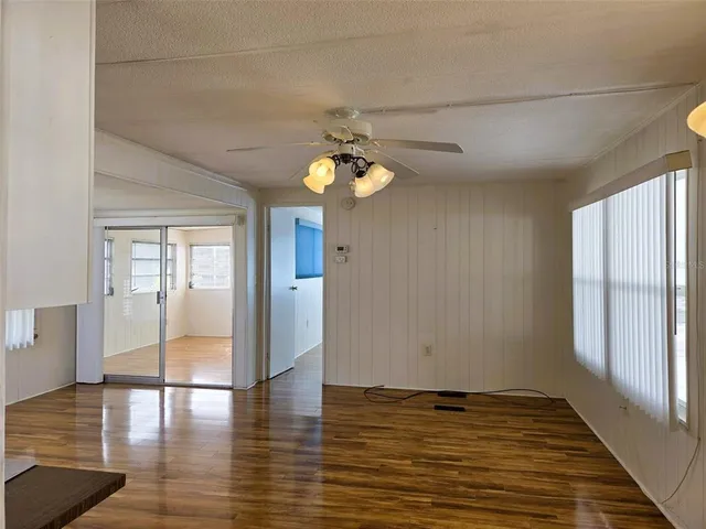 a view of a livingroom with wooden floor and a large window