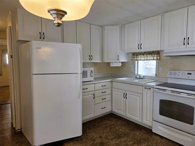 a kitchen with cabinets stainless steel appliances and a refrigerator