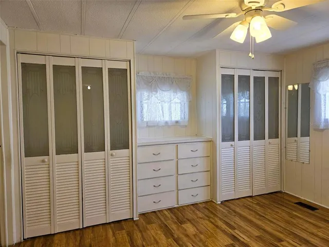 an empty room with windows and cabinet