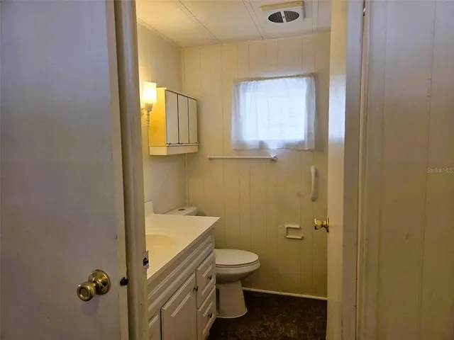 a bathroom with a granite countertop toilet and a sink
