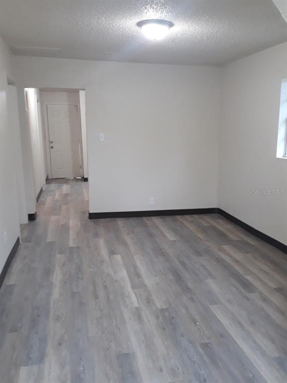 350 Maple Street Daytona Beach, FL 32114 - Photo 5 of 8 an empty room with wooden floor and windows