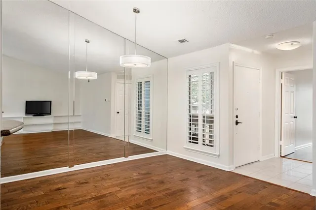 a view of an empty room with a kitchen and a window