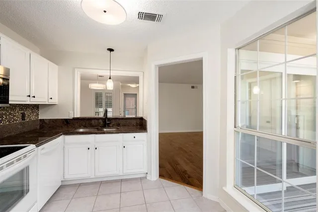 a kitchen with granite countertop a sink and cabinets