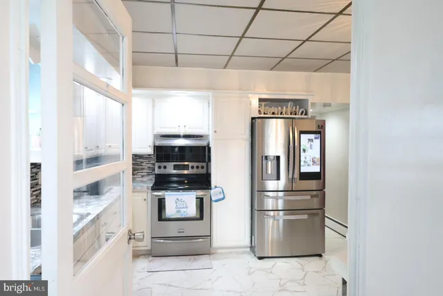 a kitchen with granite countertop white cabinets and white appliances