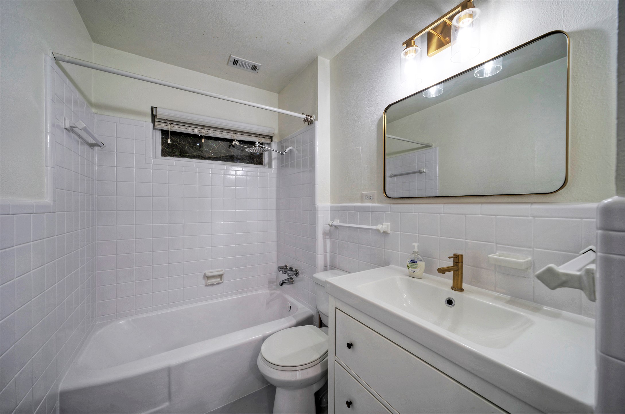 1803 Pearl Street Austin, TX 78701 - Photo 24 of 33 a bathroom with a toilet a sink a tub and mirror