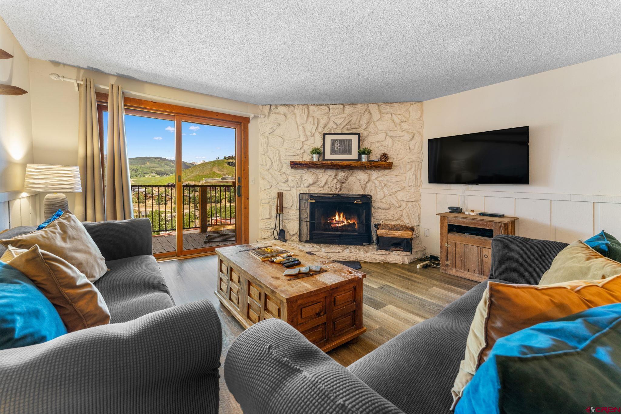 72 Hunter Hill Road, Unit I204 Crested Butte, CO 81225 - Photo 8 of 44 a living room with furniture a flat screen tv and a fireplace
