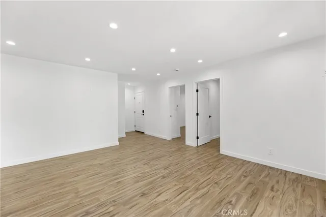 a view of an empty room with wooden floor