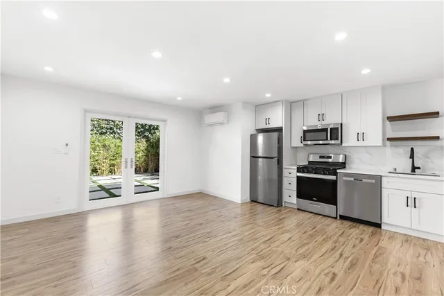 a kitchen with stainless steel appliances granite countertop a refrigerator sink and stove