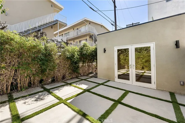 a view of a backyard with floor to ceiling window and brick wall