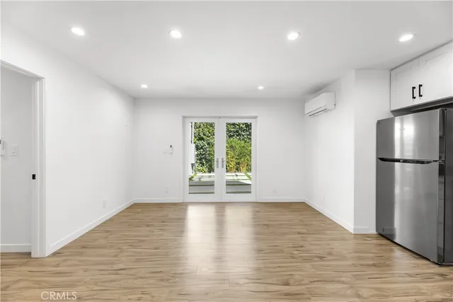 a view of a kitchen with a refrigerator and wooden floor