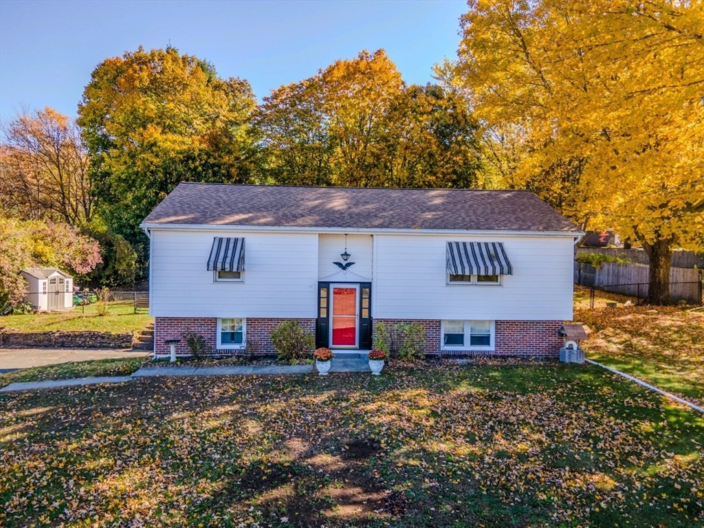 a view of a house with a yard and tree s