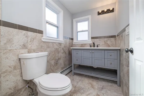 a bathroom with a toilet a sink and a window