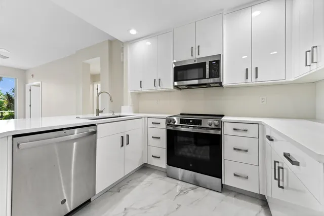a kitchen with white cabinets and stainless steel appliances