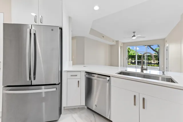 a kitchen with white cabinets and a refrigerator