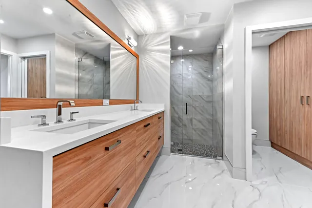 a bathroom with a granite countertop sink mirror and bathtub