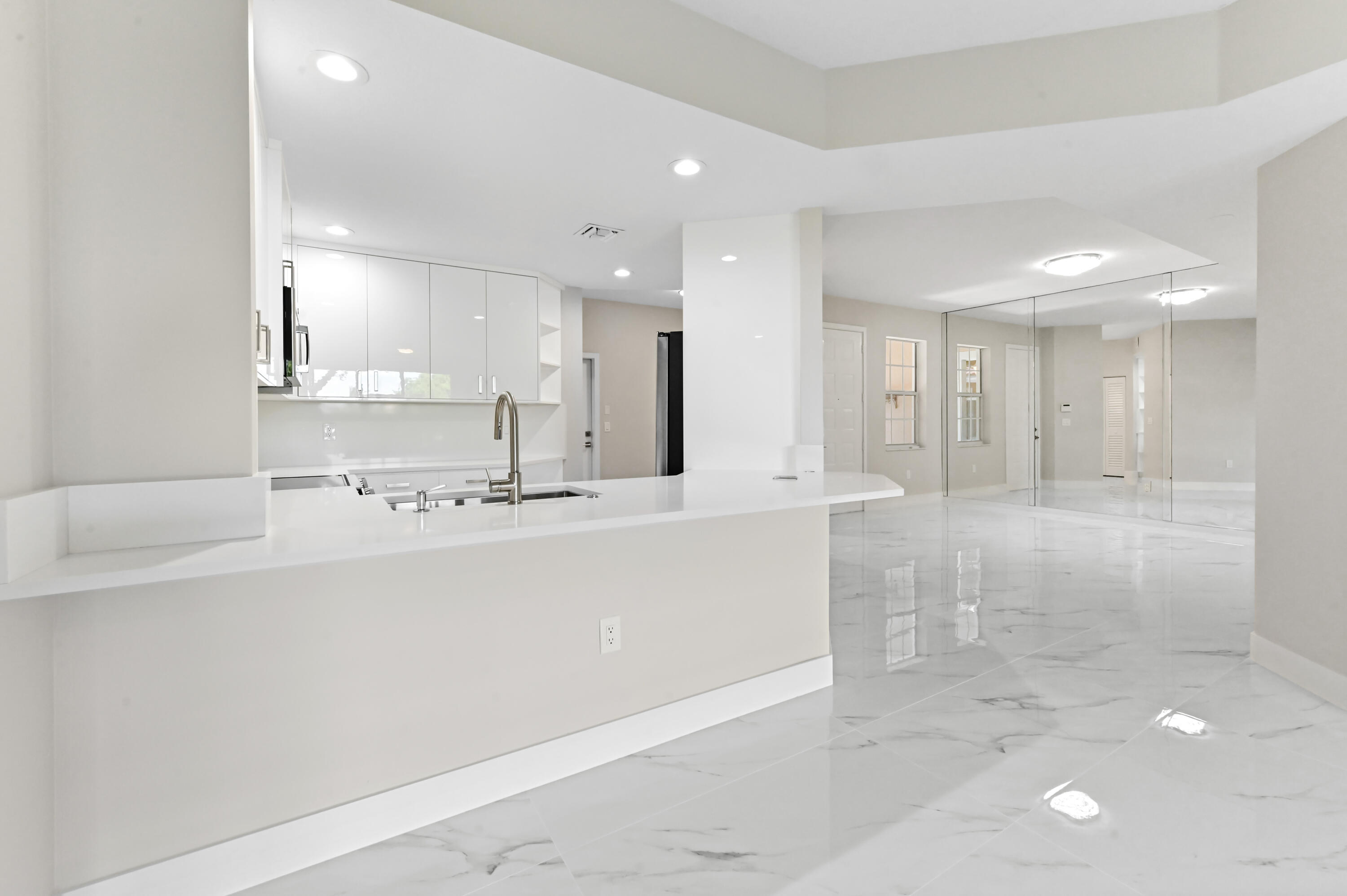 12510 Crystal Pointe Drive, Unit 102 Boynton Beach, FL 33437 - Photo 9 of 27 a view of kitchen with kitchen island a sink stainless steel appliances and white cabinets