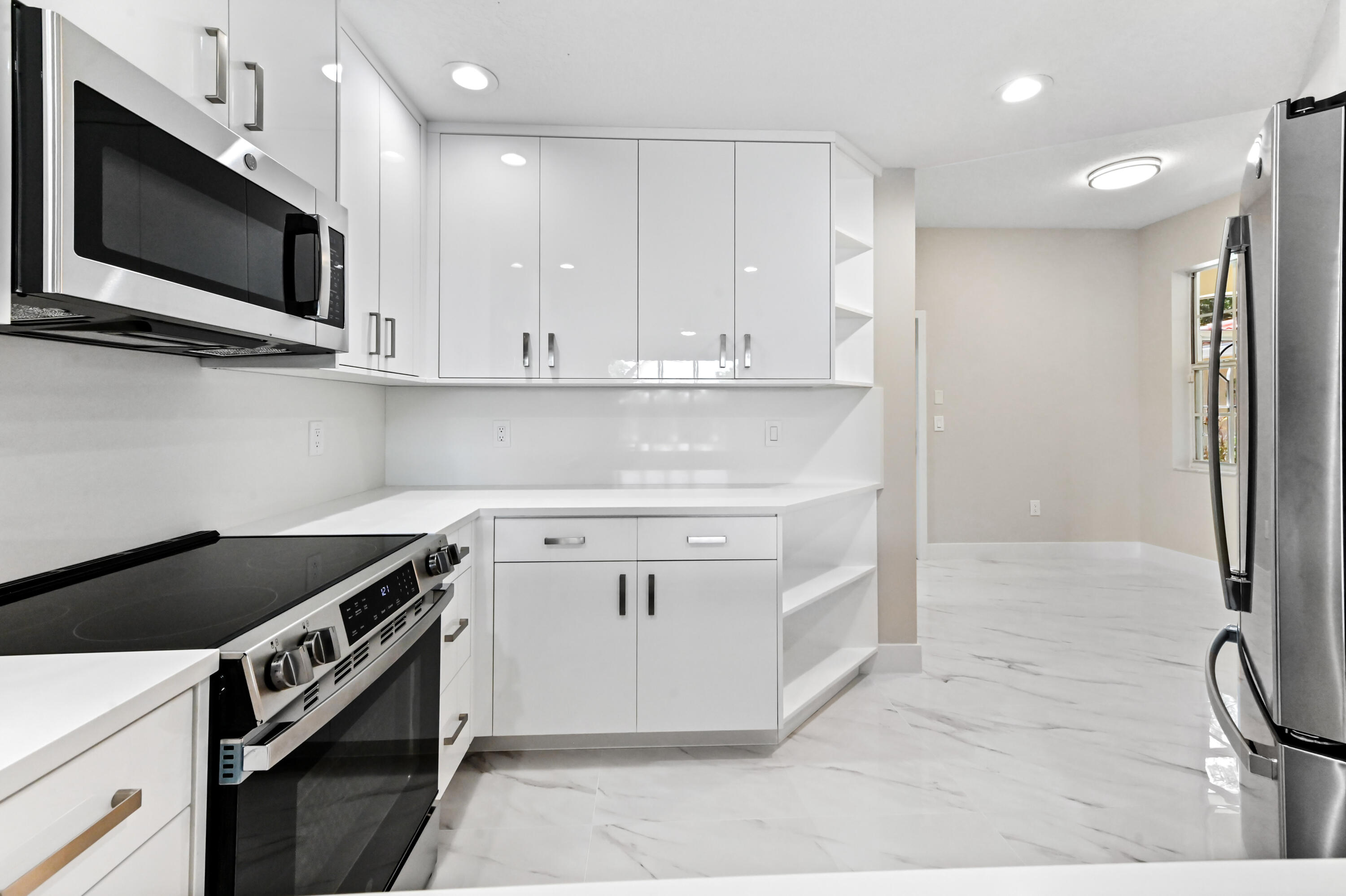 12510 Crystal Pointe Drive, Unit 102 Boynton Beach, FL 33437 - Photo 10 of 27 a kitchen with granite countertop a stove and a sink