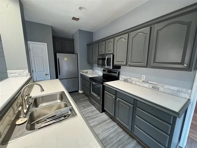 a kitchen with a sink appliances and cabinets