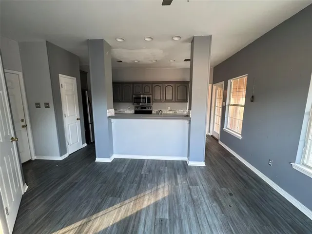 a view of a kitchen with a refrigerator wooden floor and a window