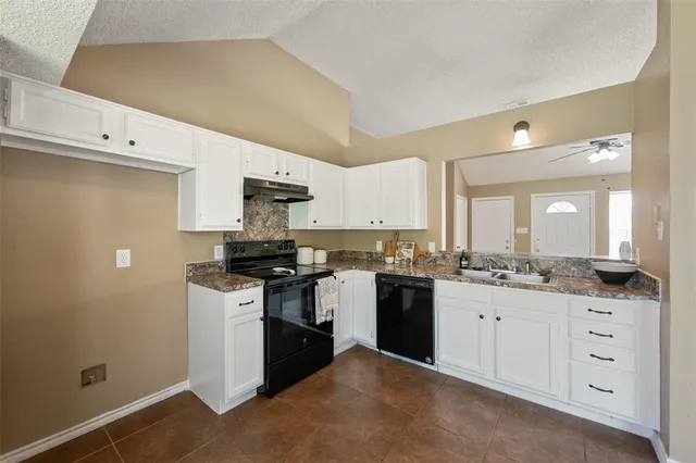 a kitchen with granite countertop a sink and a stove