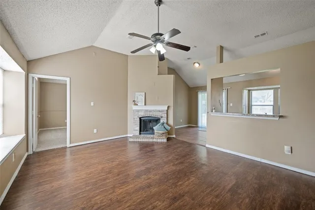 a view of an empty room with a fireplace and a window
