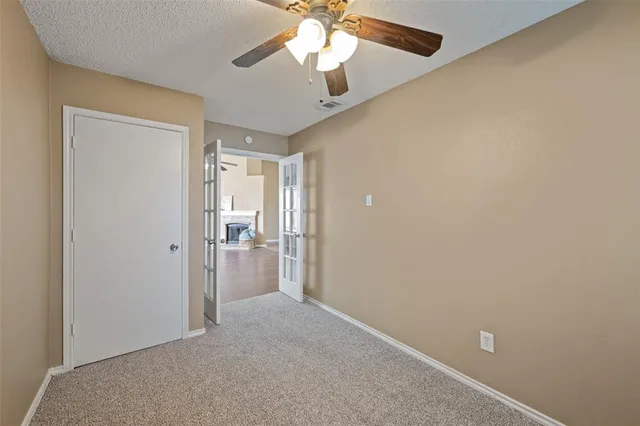 a view of a room with a ceiling fan and a window