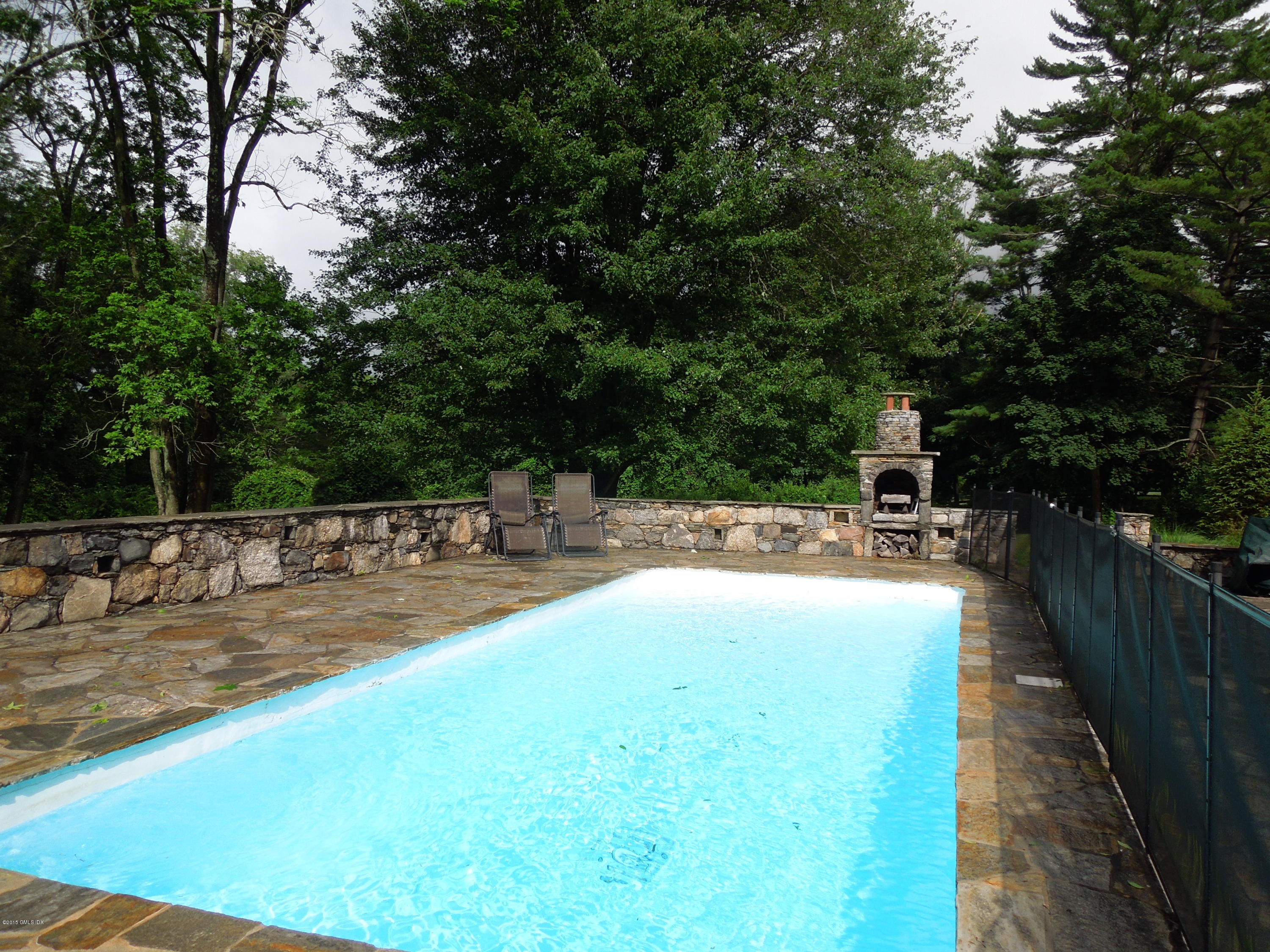408 Taconic Road Greenwich, CT 06831 - Photo 15 of 18 a view of a swimming pool with a patio and couches