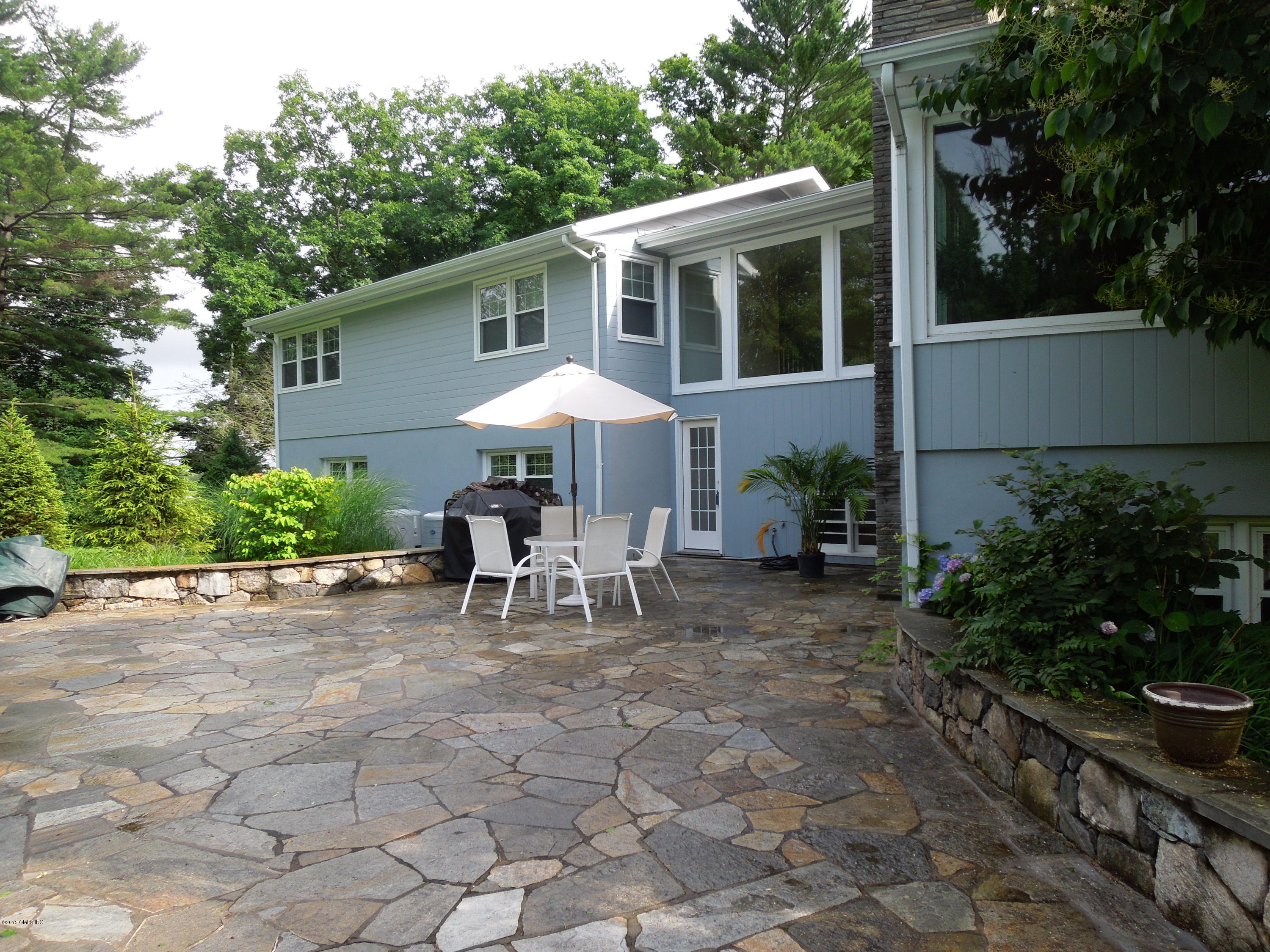 408 Taconic Road Greenwich, CT 06831 - Photo 16 of 18 a view of a house with patio and a garden