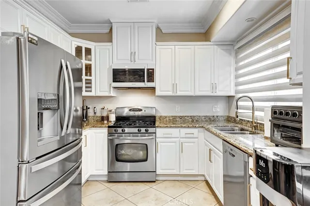 a kitchen with stainless steel appliances granite countertop a stove a refrigerator and a microwave