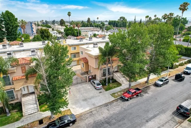 an aerial view of residential houses with outdoor space and trees