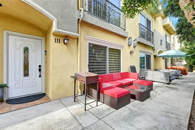 a view of a patio with a table and chairs and floor to ceiling window