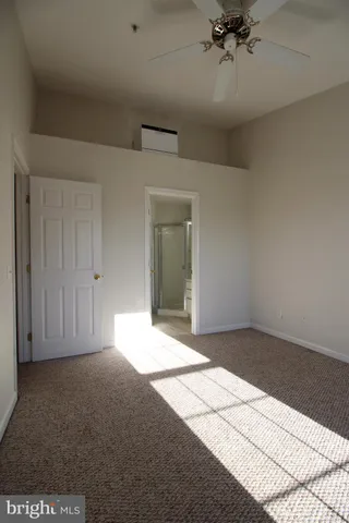 a view of an empty room and chandelier fan