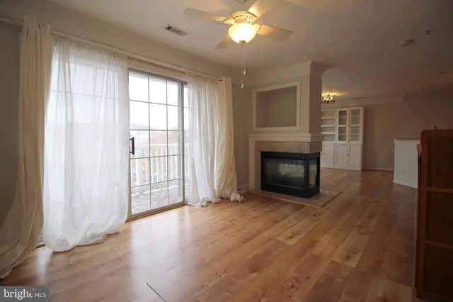 a view of a livingroom with a fireplace window and wooden floor