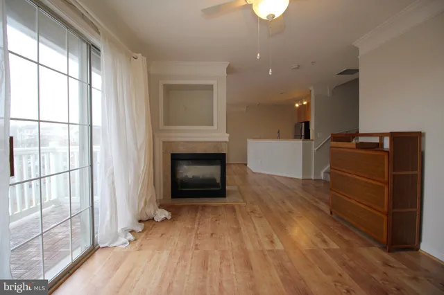 an empty room with wooden floor a fireplace and windows
