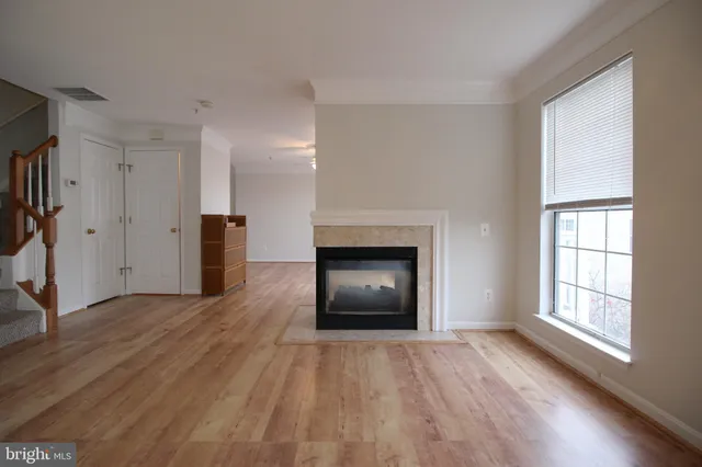 an empty room with windows and a fireplace