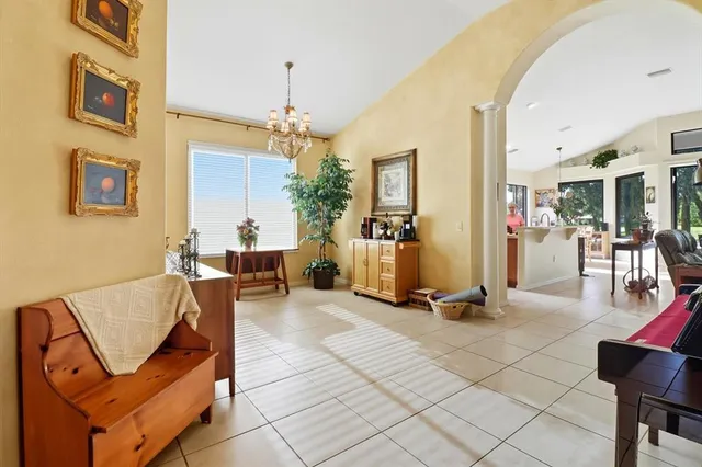 a living room with furniture a dining table and a chandelier