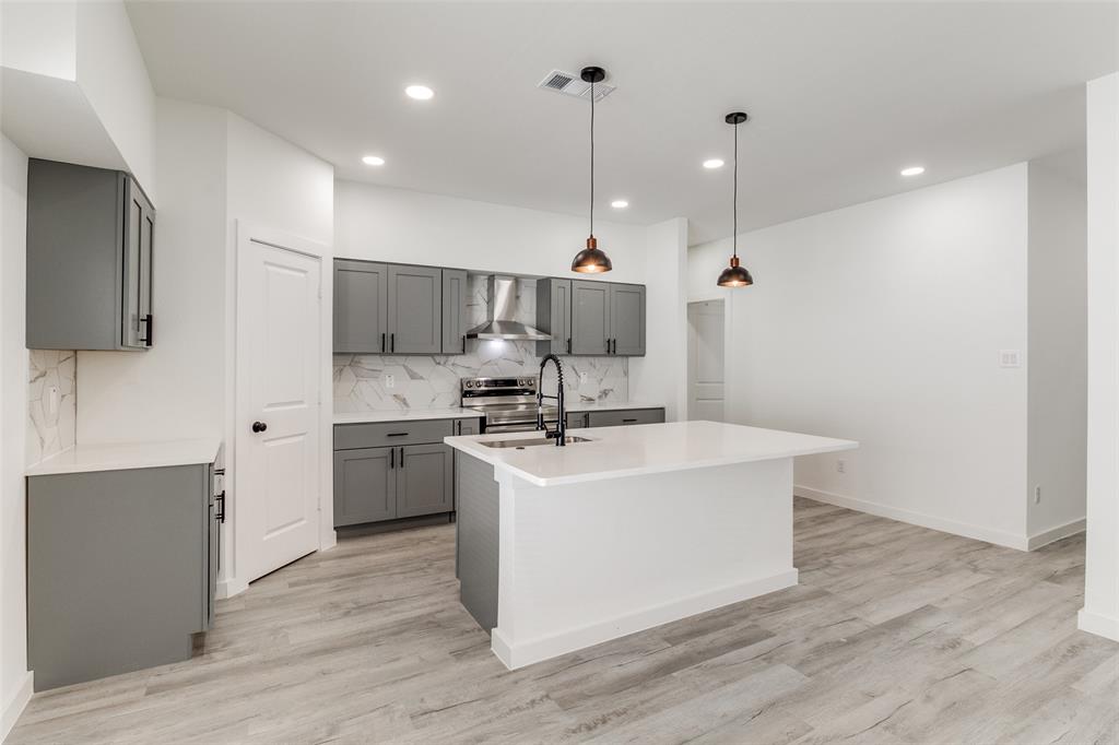 3108 Delafield Lane Dallas, TX 75227 - Photo 12 of 30 a view of kitchen with stainless steel appliances granite countertop a sink a stove a refrigerator and island with wooden floor